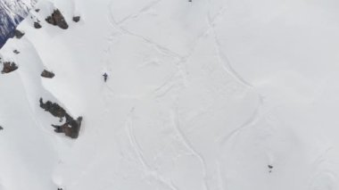 Dik bir yamaca tırmanan erkek bir kayakçının hava manzarası. Kuzey Kafkasya 'nın yüksek dağlarında kayaklarla kayak yaparak Skitour beleşçilik yapıyor.