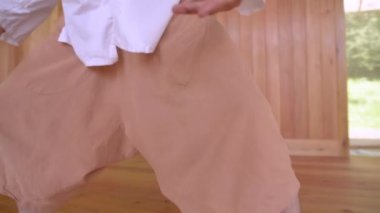 Pratik yapmak için beyaz sakallı beyaz adam salonun ahşap odasında qigong çalışıyor. Enerji uygulamasının modern gelenekleri
