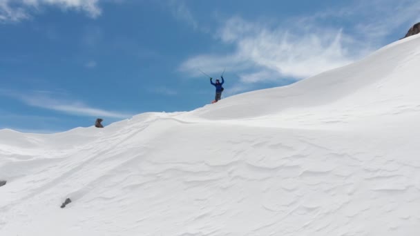 Antenne udsigt atlet skiløber Freerider starter på toppen sidelinjen højt oppe i bjergene forbereder sig på at stige ned. Skitour og freeride på de uforberedte skråninger i det nordlige Kaukasus – Stock-video