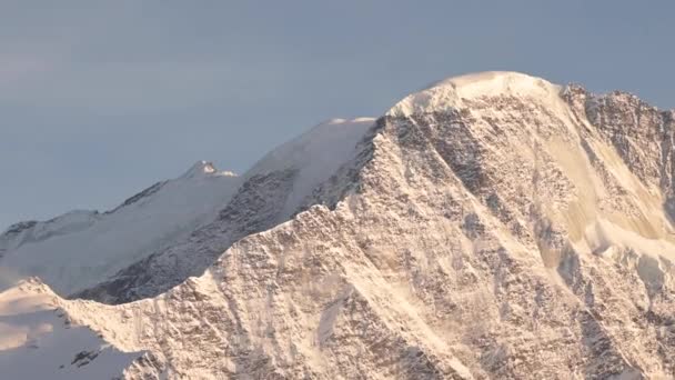 Hand-held panorama van besneeuwde rotsachtige bergtoppen. Levenscamera bergen bij zonsondergang — Stockvideo