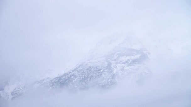 Низкое время контраста. Высоко в горах, низкие облака и туман скрывают скалистую гору — стоковое видео