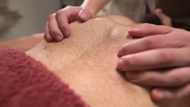 Massage sportif professionnel des muscles pectoraux des athlètes dans une pièce sombre. Gros plan — Video
