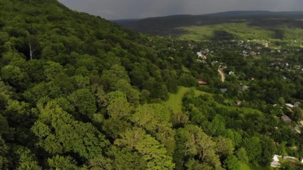 Luftaufnahme eines Dorfes in den Bergen in einem tiefen Wald. Vor dem Sturm-Video. Filmkorn — Stockvideo