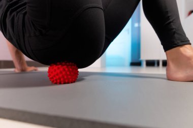 Yakın plan Atletik Kafkasyalı ince kadın masaj odasında kalçasına ve kalça kaslarına miyofasyal masaj yapıyor.