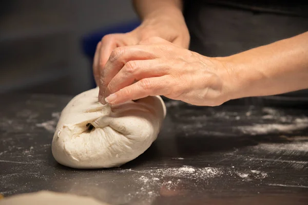 Zbliżenie żeńskich rąk ugniatających ciasto do pieczenia chleba rzemieślniczego w piekarni domowej — Zdjęcie stockowe