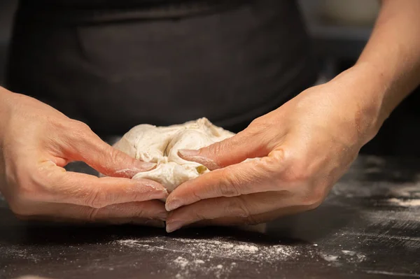 Primer plano de las manos femeninas amasando masa para hacer pan artesanal en la panadería casera — Foto de Stock