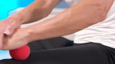 Kafkasyalı genç bir kadının kalçasına ve kalçasına masaj yapan bir masaj minderinin üzerinde miyofasyal masaj yaptığı yakın plan. 4k çözünürlüğü
