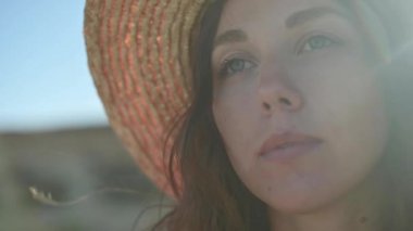 Yakın çekim şehvetli zevk. Kafkasyalı güzel bir kadının ağır çekim yüzü bulanık. Rüzgar saçlarını okşar ve dalgalar. Saça odaklan. Deniz ufkunun arka planında.