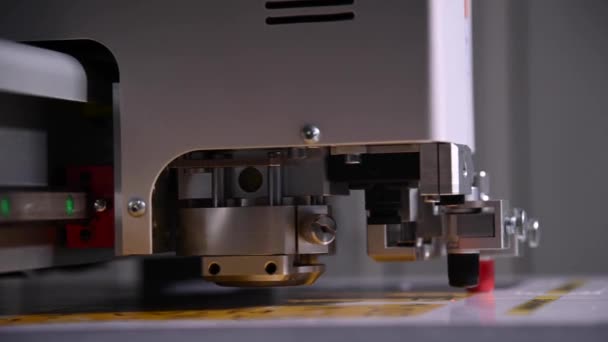Industrie Eine Großaufnahme eines industriellen Plotters schneidet eine Schablone auf eine Kartonverpackung für Produkte. Echtzeit-Schärfentiefe. Live-Kamera — Stockvideo