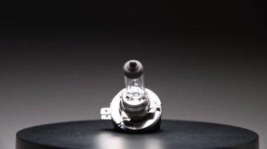 Yeni yedek parça siyah bir gradyan arka planda döner. Bir araba ampulü. h8b