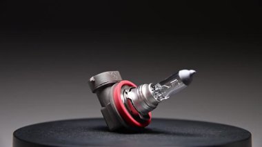 Yeni yedek parça siyah bir gradyan arka planda döner. Bir araba ampulü. h9