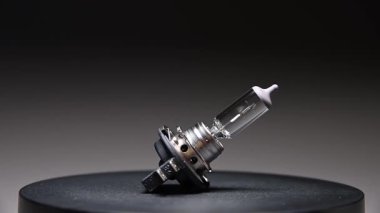 Yeni yedek parça siyah bir gradyan arka planda döner. Bir araba ampulü. h7 halojen