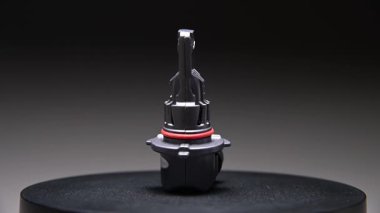 Yeni yedek parça siyah bir gradyan arka planda döner. Bir araba ampulü. hb3 Öncülüğünde