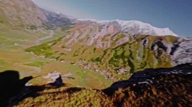 FPV insansız hava aracı keskin dağ uçurumları üzerinde uçuyor. Dağlara düşen bir uçurumun havadan görünüşü. Kayalık dalış