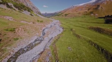 Yazın dağlık bölgelerdeki pitoresk bir dağ nehrinin havadan görünüşü. Güneşli bir yaz gününde FPV dronu kullanılarak vuruldu. Doğa gözlemi için mükemmel.