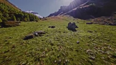 Dik, kayalık bir dağ tırmanışının ve güneşli bir günde güzel, taşlı bir yamacın hızlı ve aşırı yakın çekimi. Bir FPV İHA düzgünce ve hızla yamaca doğru uçar.