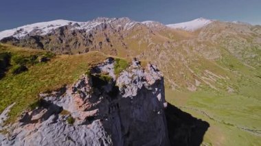 Güneşli bir günde yüksek hızda bir FPV İHA ile bir dağ uçurumunun son derece yakın uçuşu. Dağlarda yüksek dalış kuadkopteri ve İHA uçuşları