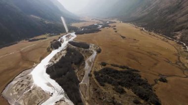Güneşli bir sonbahar gününde bir dağ geçidinde akan küçük bir ırmağın yukarıdan görünüşü..