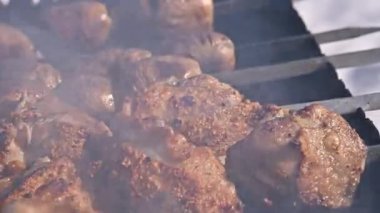 Yakın plan ateşte kızartılmış sulu et, dumanlı et. Şiş kebap sıcak kömürlerin üzerinde pişirilir. Izgarada et pişirme kavramı