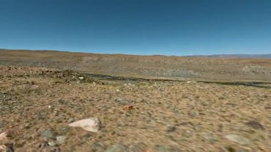 Bir dağ manzarası nehrinin yanından geçen bir off-road aracının görüntüsü. Aksiyon kamerasıyla çekilmiş.