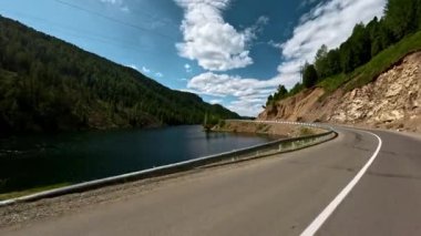 Arabanın ön camından birinci şahıs görüntüsü. Asfalt bir dağ yolunda araba kullanmak. Aksiyon kamerasıyla çekilmiş.