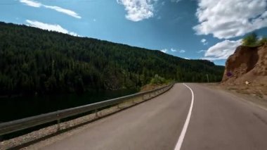 Arabanın ön camından birinci şahıs görüntüsü. Asfalt bir dağ yolunda araba kullanmak. Aksiyon kamerasıyla çekilmiş.