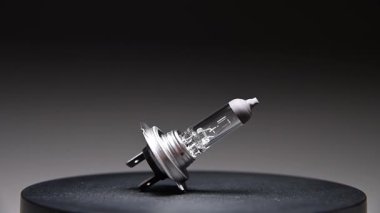 Yeni yedek parça siyah bir gradyan arka planda döner. Bir araba ampulü. h7 halojen