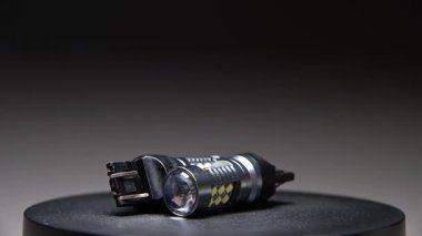 Farklı tabanlara sahip LED ampuller gri bir gradyan arkaplan üzerinde döner. Arabanın iç ve dış aydınlatma için yeni parçalar