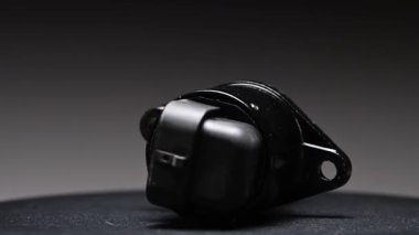 Araba transmisyonu için yeni bir ters vites sensörü. Yeni parça gri bir gradyan arkaplan üzerinde döner