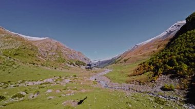 Bir helikopterin dağlarda kargo sapanlarıyla yaptığı hava görüntüsü. Dağlarda vuruldum.