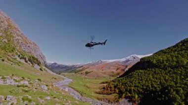 Bir helikopterin dağlarda kargo sapanlarıyla yaptığı hava görüntüsü. Dağlarda vuruldum.