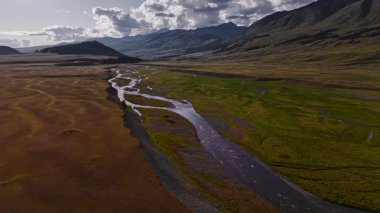 Serseri. Gün batımında bozkır bir dağlık alanda bir dağ nehri akıntısı çok sayıda dökülür. Doğadaki tatlı su kaynakları. Hava görüntüsü. Doğal temiz su kaynakları.