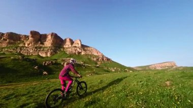 Motosikletli birinin toprak yolda dağ bisikleti sürerken çekilmiş bir FPV görüntüsü. Erkek bisikletçinin dağlardaki doğa sporunun en üst görüntüsü.