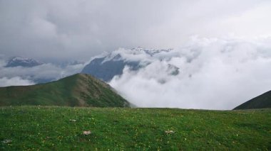 Akşam manzarası alacakaranlıkta dağların üzerinde sürünen alçak bulutlar. Bulutların hızlı hareketi. Gerçek zamanlı 4k