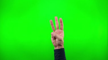 El hareketlerinin yakın plan çekimi, erkek eli kareye girer ve yeşil arka planda üç numaralı hareketi gösterir..