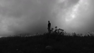 Yoğun bir çalışmadan sonra bir koşucu yoğun bir çimenlikte duruyor. Düzenli egzersiz inanılmaz sonuçlar almanıza yardımcı olacaktır. Uzun mesafe koşusu sırasında dinlenin..