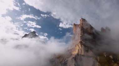 Hava manzaralı sinemalar bulutların arasında süzülür. Alçak bulutlar, destansı dağlık arazide kaya oluşumlarında yatar. Fpv İHA görüntüsü