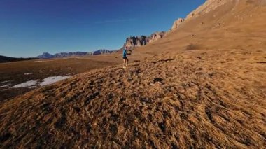 Spor giyimli bir adamın tarlalarda hızla koşarkenki görüntüsü. Dağlarda karla kaplanmış doğa sporu yapan bir adam. Bacaklarının altından bak, sağlıklı bir yaşam tarzı..