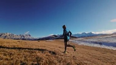 Atlet erkek koşucunun hava görüntüsü. Dağlarda koşma eğitimi. Fpv insansız hava aracından hava görüntüsü.