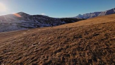 Spor giyimli bir adamın tarlalarda hızla koşarkenki görüntüsü. Dağlarda karla kaplanmış doğa sporu yapan bir adam. Bacaklarının altından bak, sağlıklı bir yaşam tarzı..