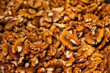 Çiğ, kabuklu ceviz, arka planda bir sürü fındık. Açık kahverengi, kırık ceviz, taze hasat.