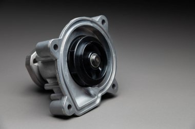 Gri eğimli arka planda bir yolcu aracının içten yanmalı motoru için yeni soğutma pompası