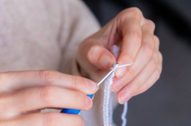 Genç mutlu kadın evde tığ işi yapıyor, dinleniyor ve meditasyon yapıyor..