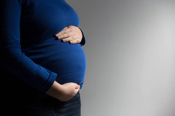 Esperando a mamá sosteniendo su barriga — Foto de Stock