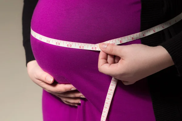 Werdende Mutter misst ihren Bauch — Stockfoto