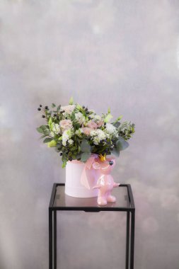 Işık arkaplanındaki masada vazodaki çiçekler 