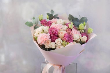 Işık arkaplanındaki masada vazodaki çiçekler 