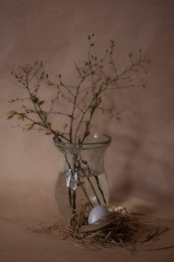 Paskalya kahvaltısı sahnesi. Renkli pastel yumurtalar ve gri ahşap arka planda taze bahar çiçekleri ile eski tarz dekorasyon..