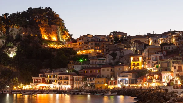 Noite em Parga, Grécia. Uma vista na fortaleza, casas e barcos perto da costa rochosa . — Fotografia de Stock