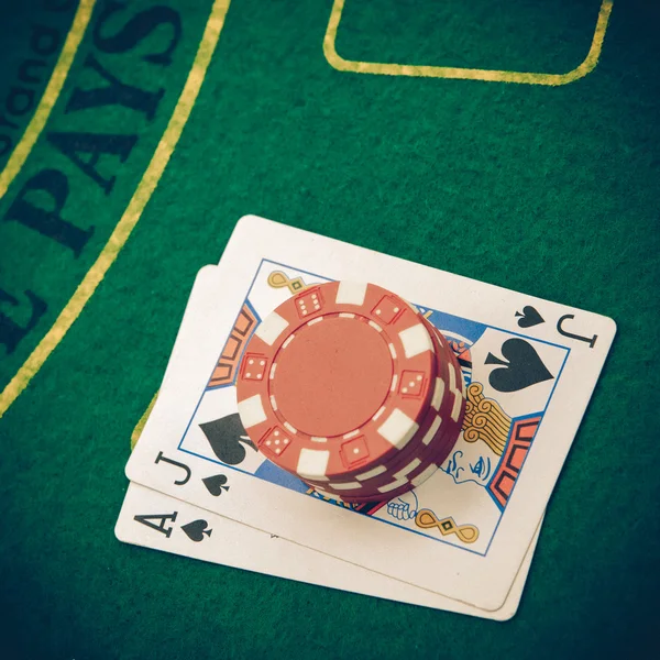 Ace of hearts and black jack with red poker chips — Stock Photo, Image